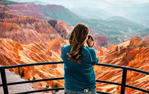Woman holding a camera at the Sunset Overlook in Cedar Breaks National Monument.