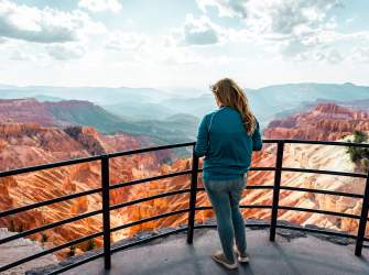 Woman in blue standing at the scenic Sunset Overlook at Cedar Breaks National Monument